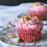 Pistachios & Rosewater Cupcakes with pink frosting and pistachio topping in floral cupcake liners.