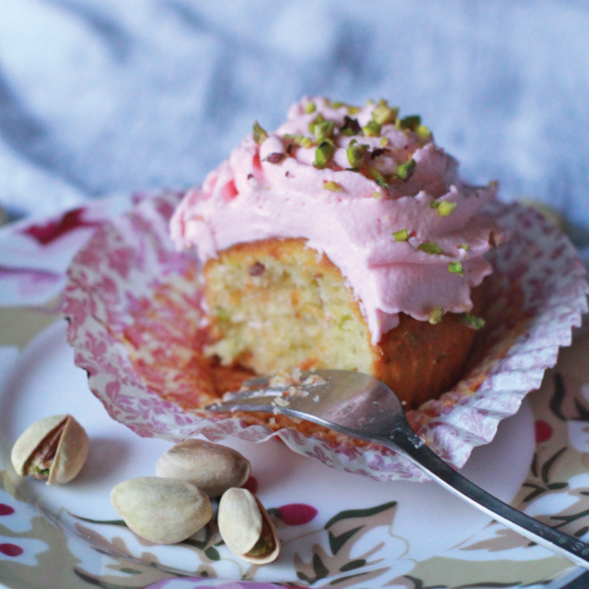 Indulge in the delicious layers of Rosewater and Pistachio Cupcakes, featuring a moist interior and creamy pink frosting.