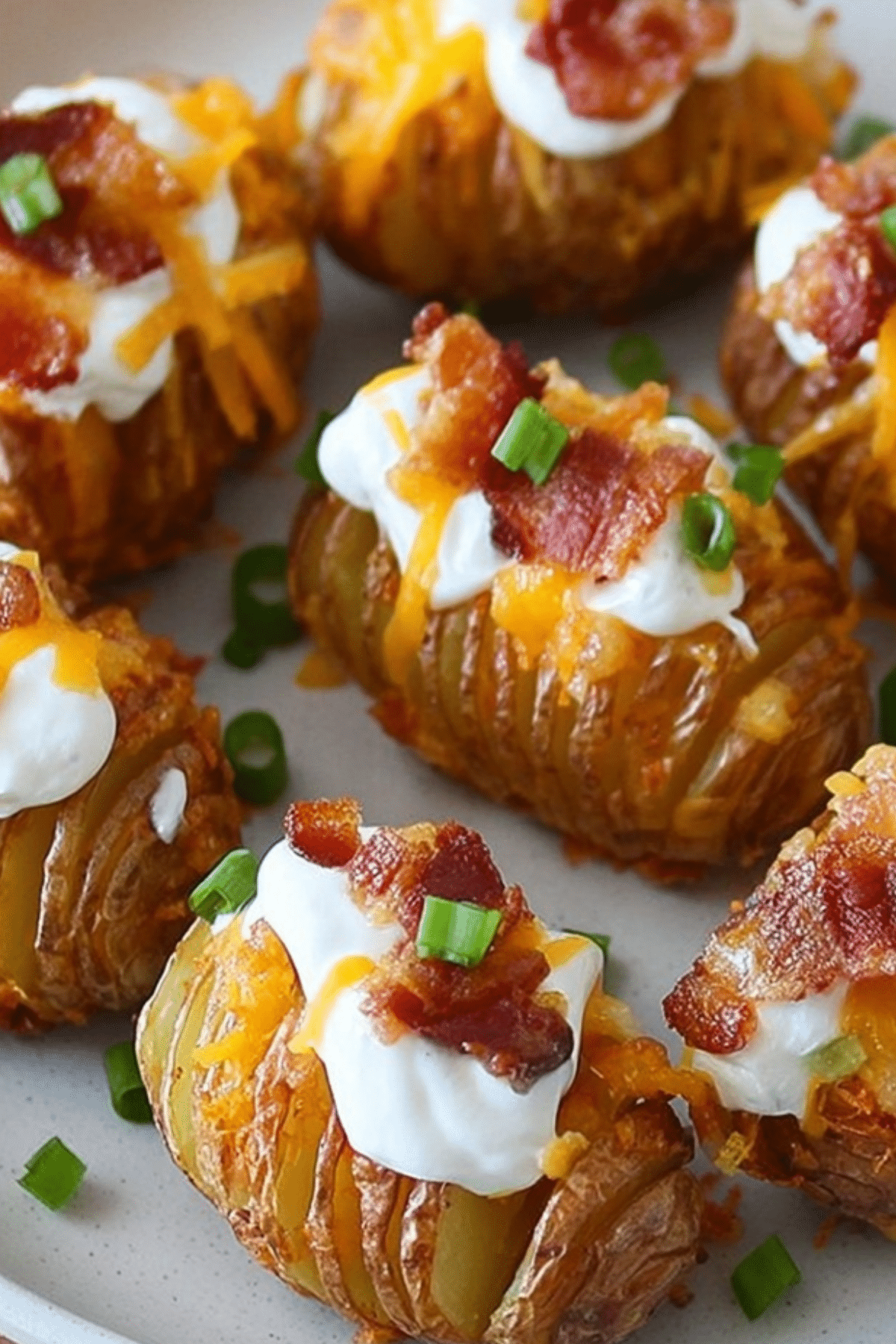 Crispy Loaded Hasselback Potato Bites with melted cheese and crispy bacon