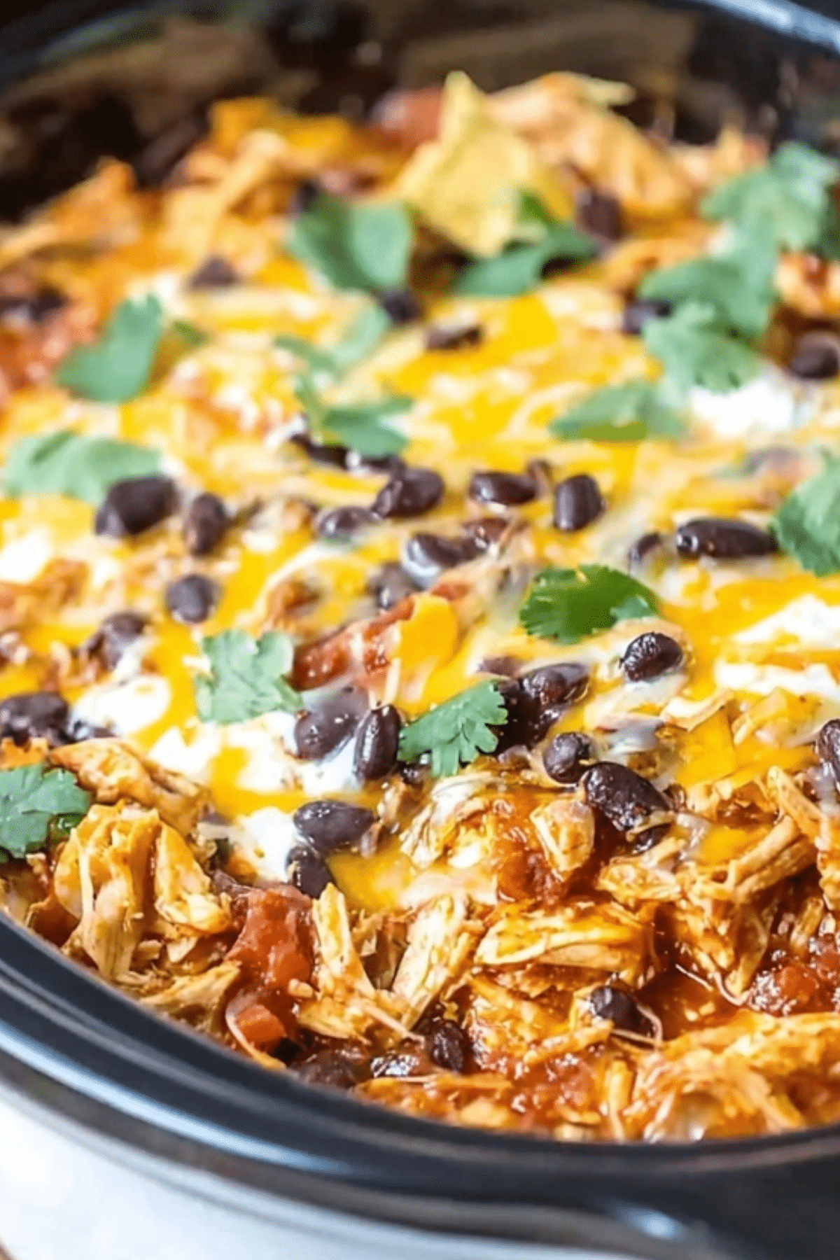 Crockpot Chicken Enchilada Casserole recipe with melted cheese and black beans