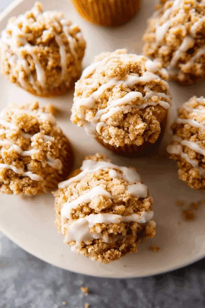 Pumpkin Crumb Cake Muffins topped with a pumpkin spice crumble and maple icing