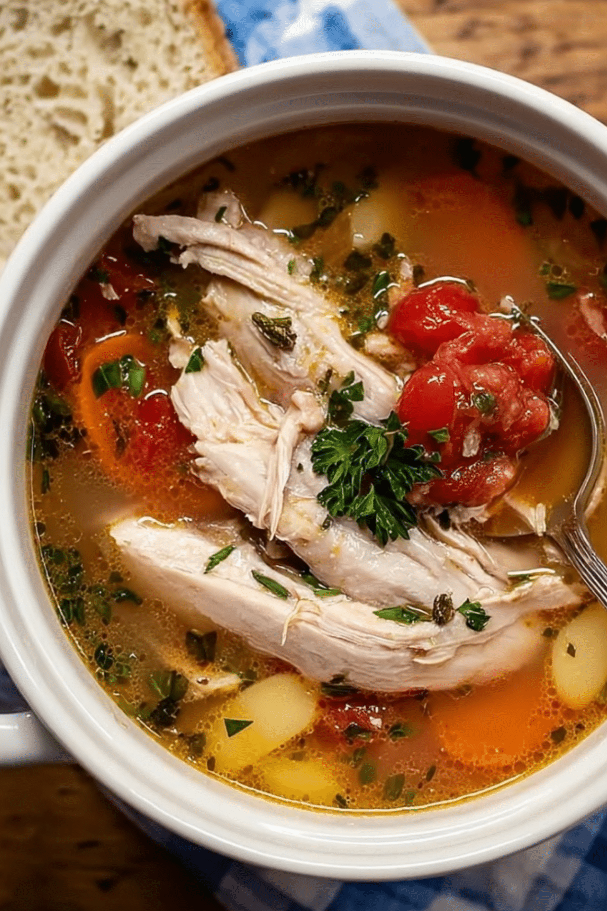A bowl of creamy Tuscan Chicken Soup filled with vegetables and shredded chicken.