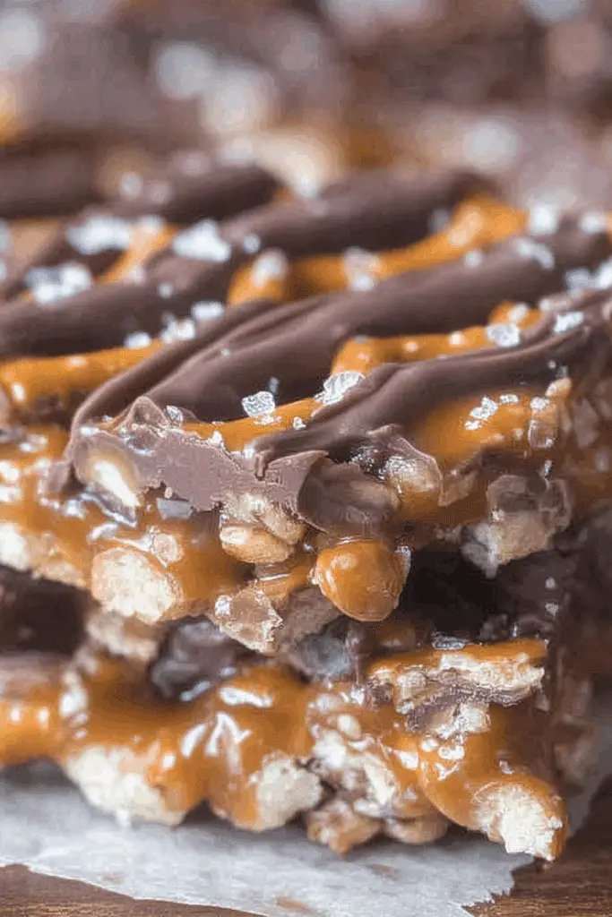 Salted Chocolate and Caramel Pretzel Bars on parchment paper with sea salt