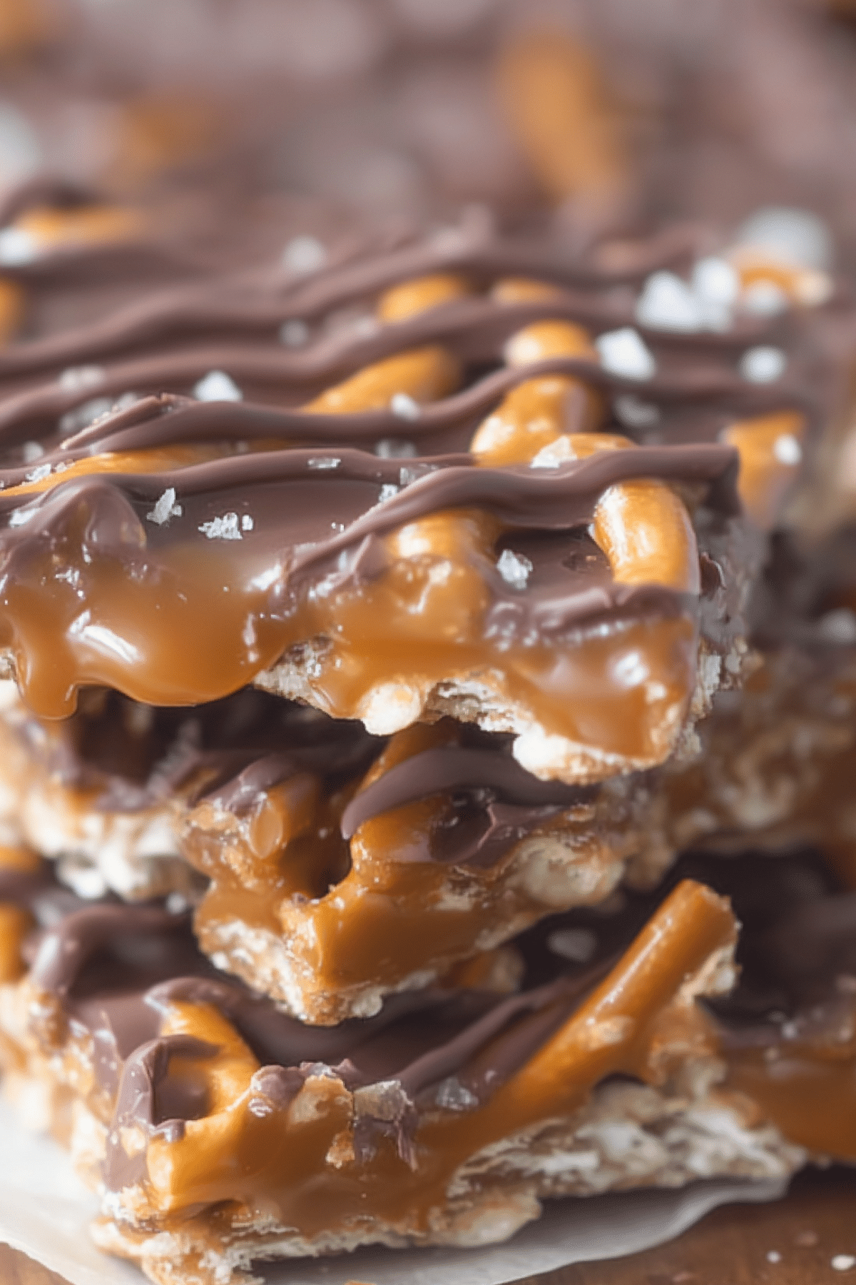 Salted Chocolate and Caramel Pretzel Bars on parchment paper with sea salt