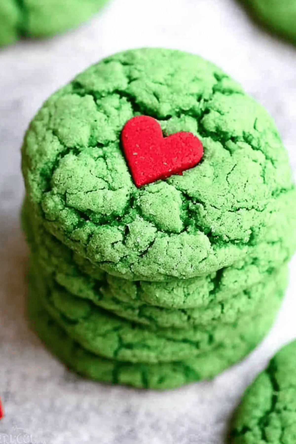 Crinkly Grinch Cookies with green color and red heart sprinkle