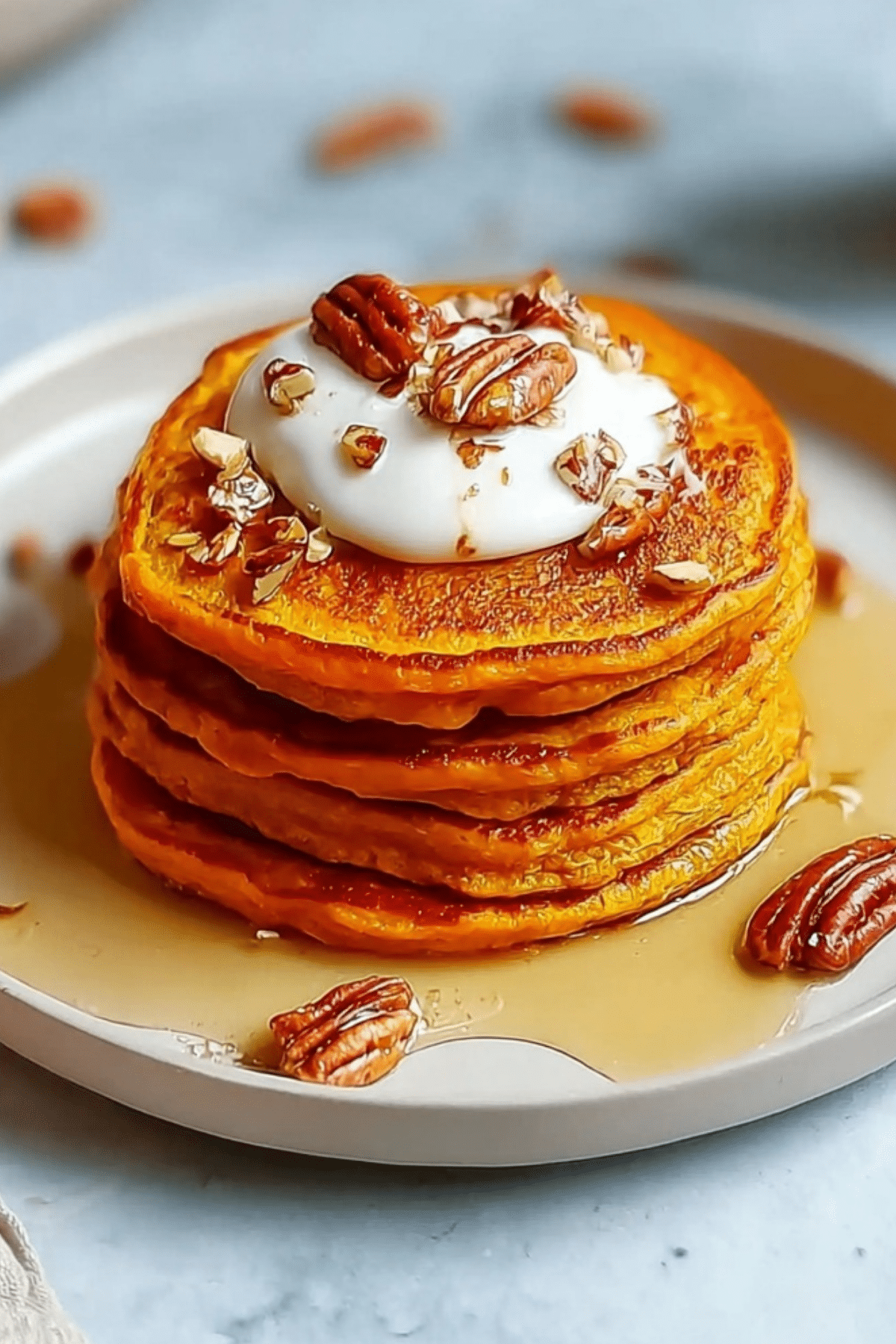 Fluffy Sweet Potato Pancakes stacked with syrup