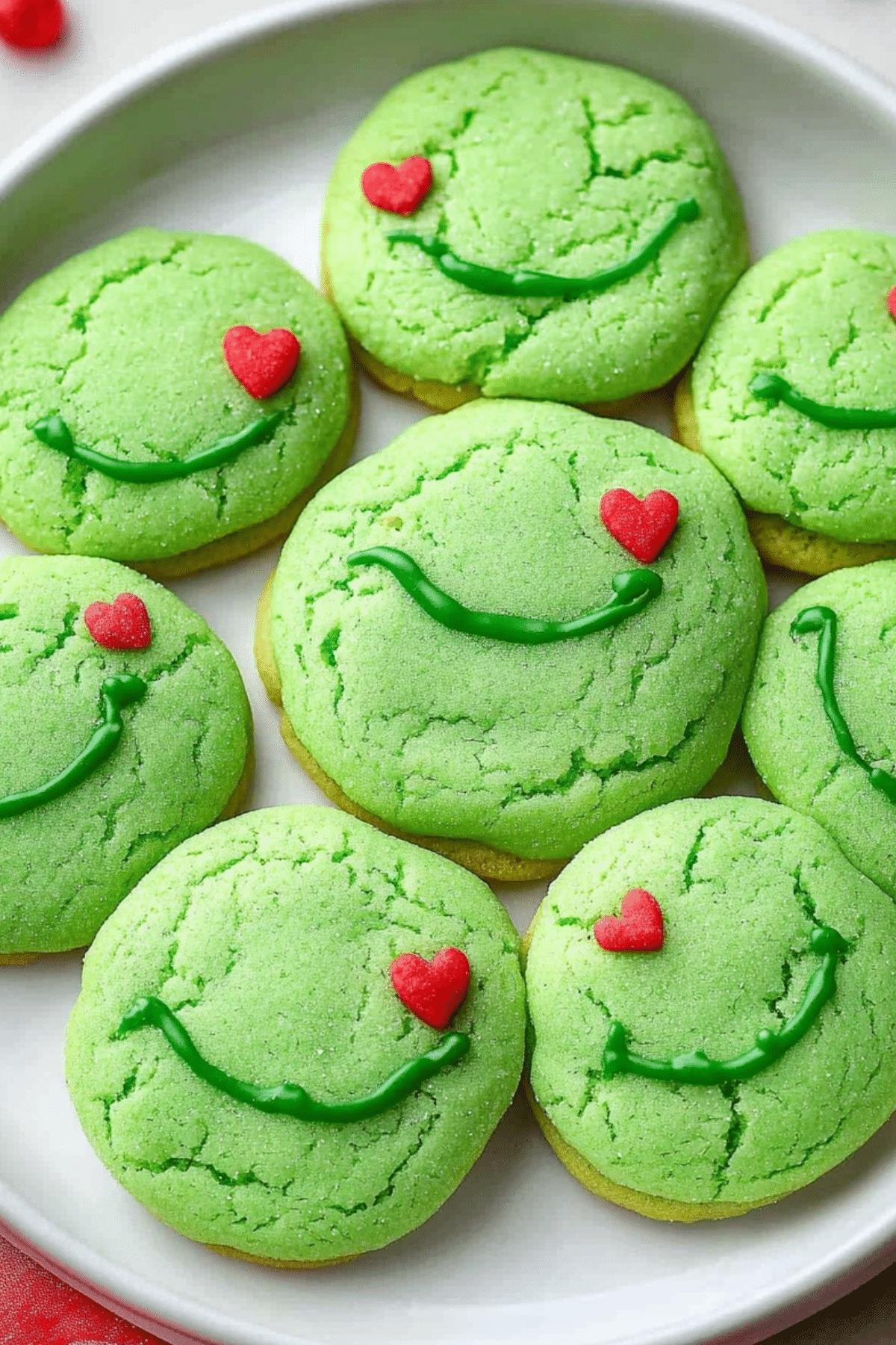 Grinch Sugar Cookies with red heart sprinkles for Christmas