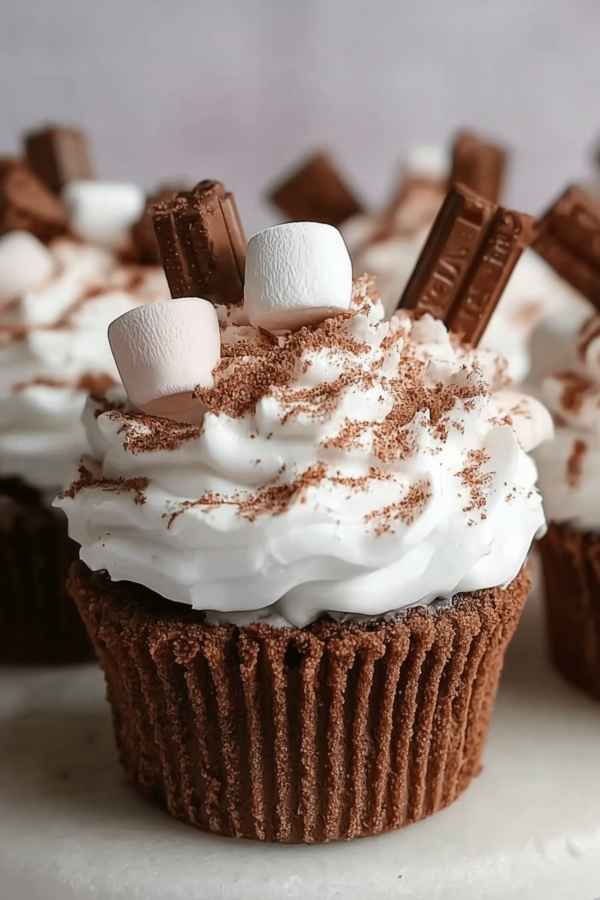 Hot Chocolate Cupcakes topped with marshmallow frosting and chocolate flakes