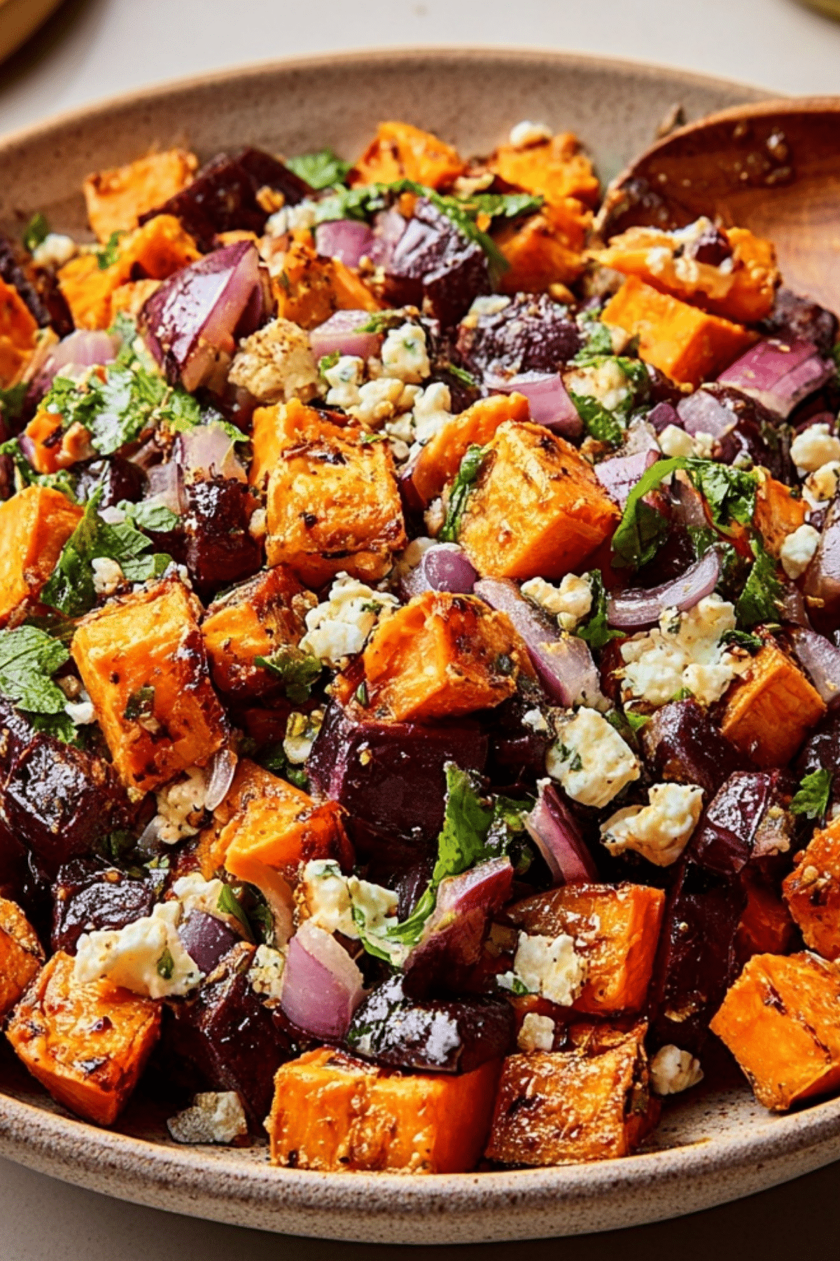 Bowl of Irresistible Roasted Sweet Potato Salad with spinach, feta, and pecans