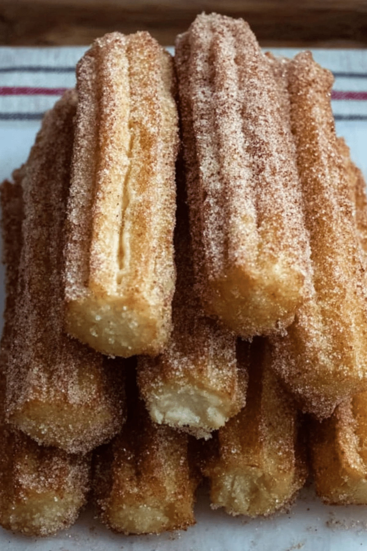Baked churros with cinnamon sugar coating on a white plate