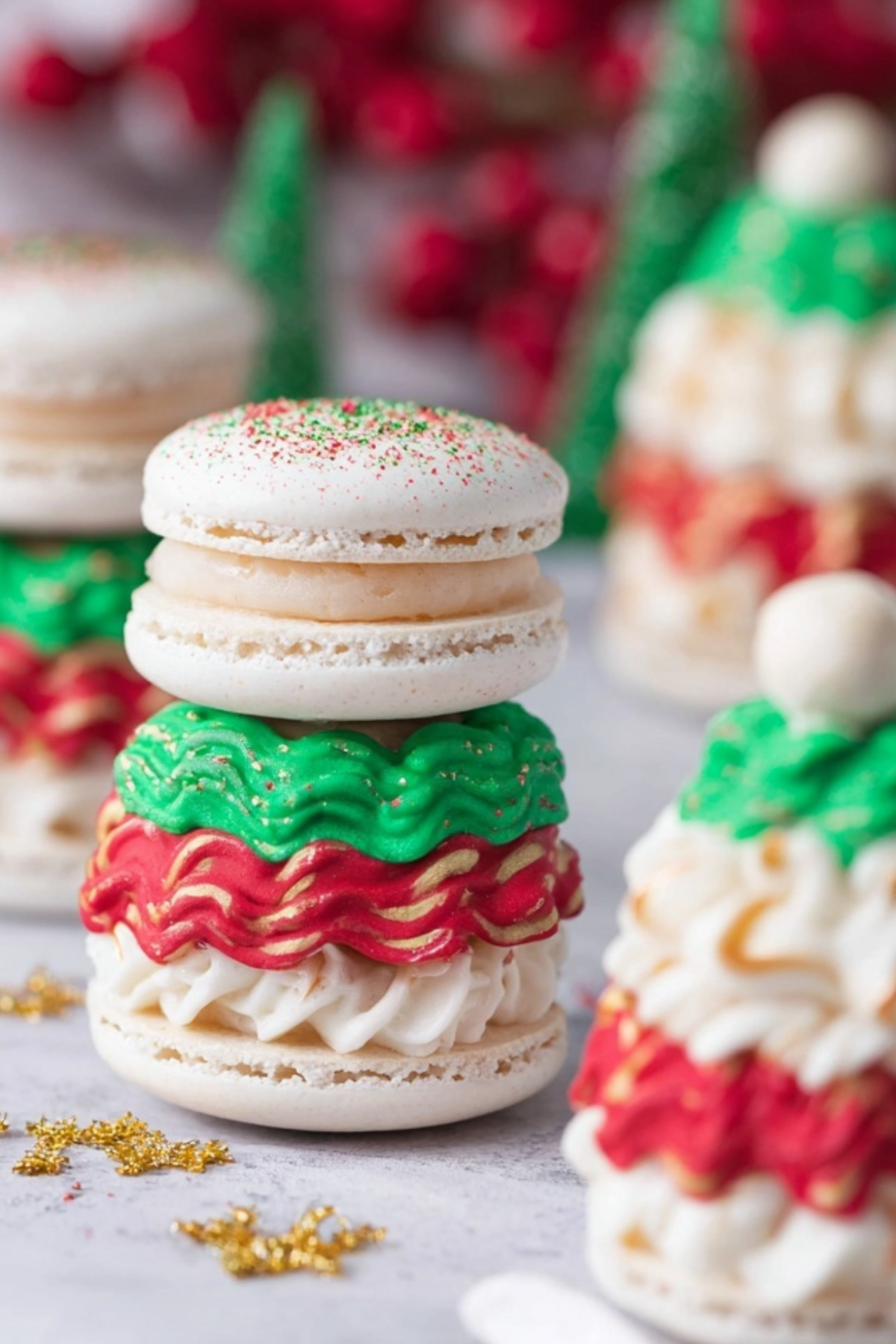 Christmas Tree Cake Macarons decorated with green sprinkles and white chocolate topping.