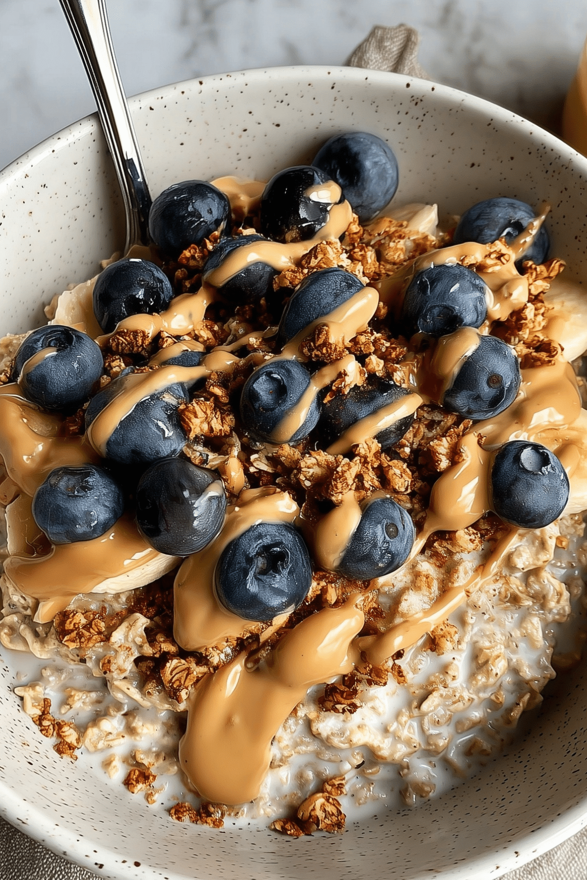 Jar of creamy Classic Overnight Oats topped with fruit and granola