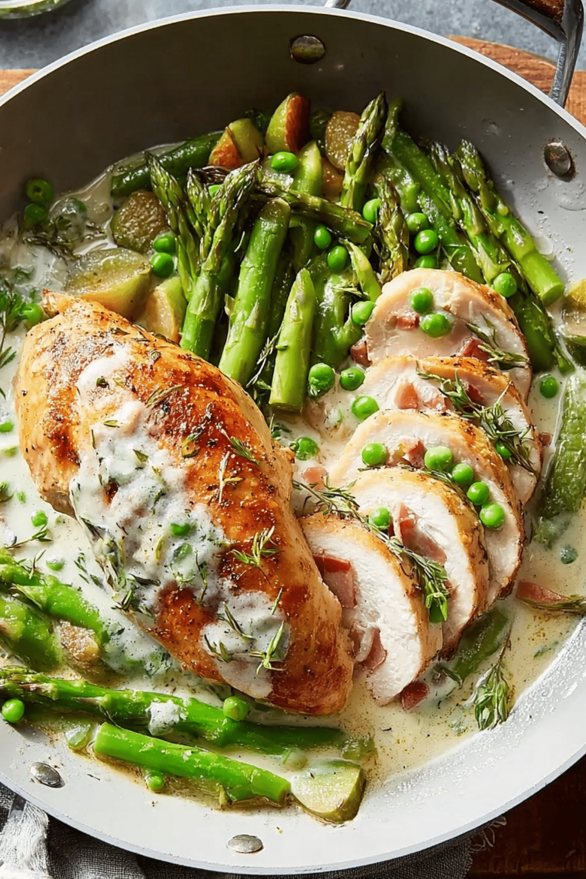 Fontina & Prosciutto Stuffed Chicken with Spring Vegetables in a skillet