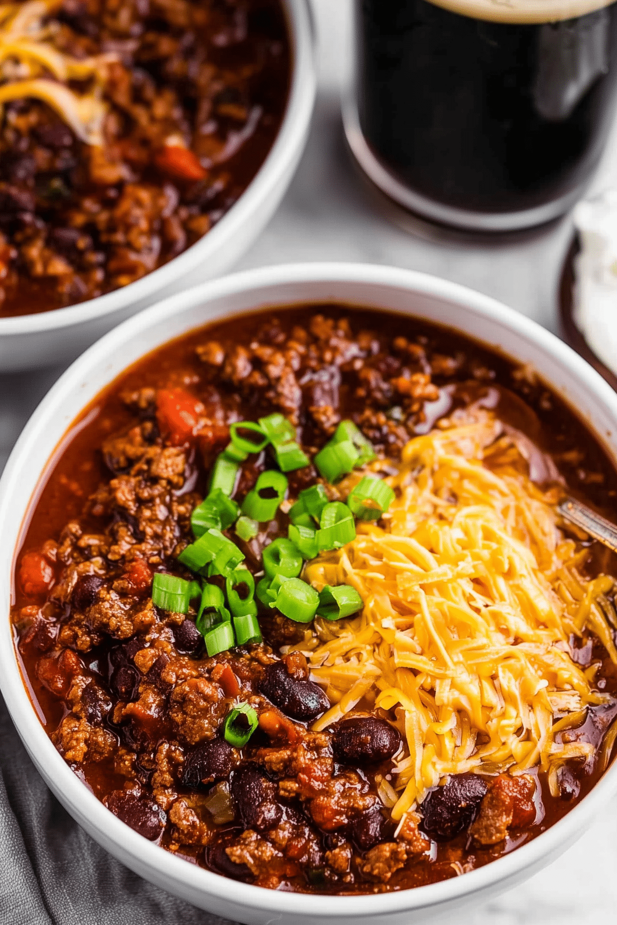 Guinness Spiked Irish Chili served in a bowl with cheddar and sour cream