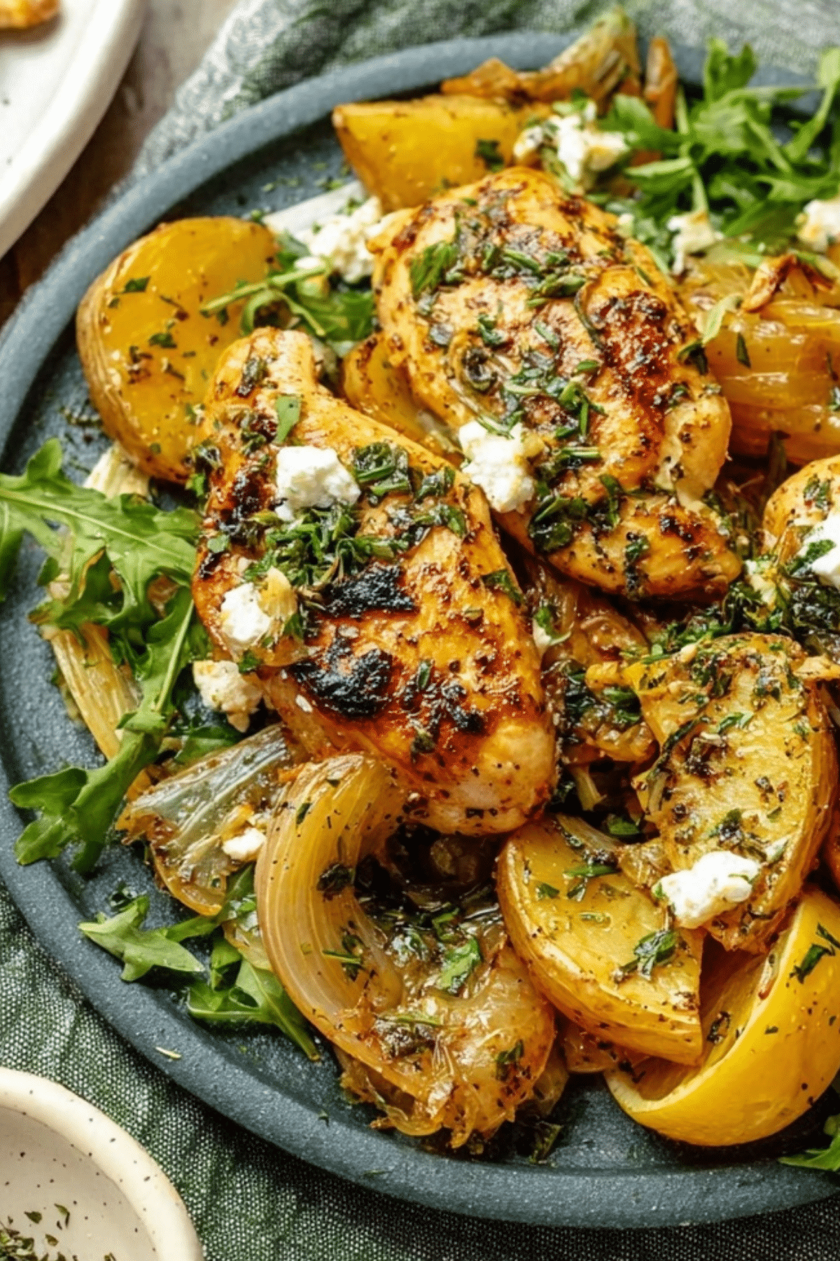 Herby Lemon Garlic Chicken and Potatoes on a sheet pan with fresh herbs and lemon slices