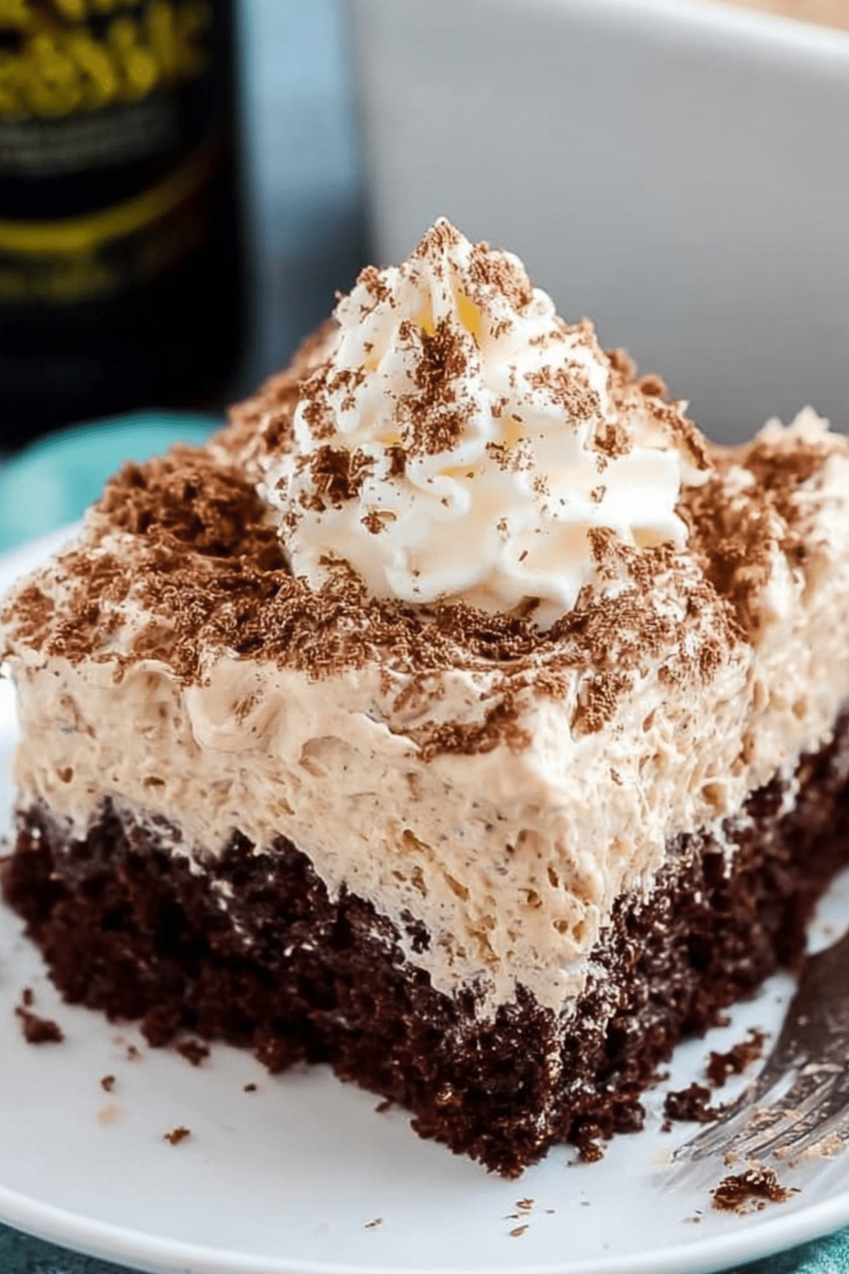 Irish Cream Poke Cake topped with whipped cream and chocolate shavings