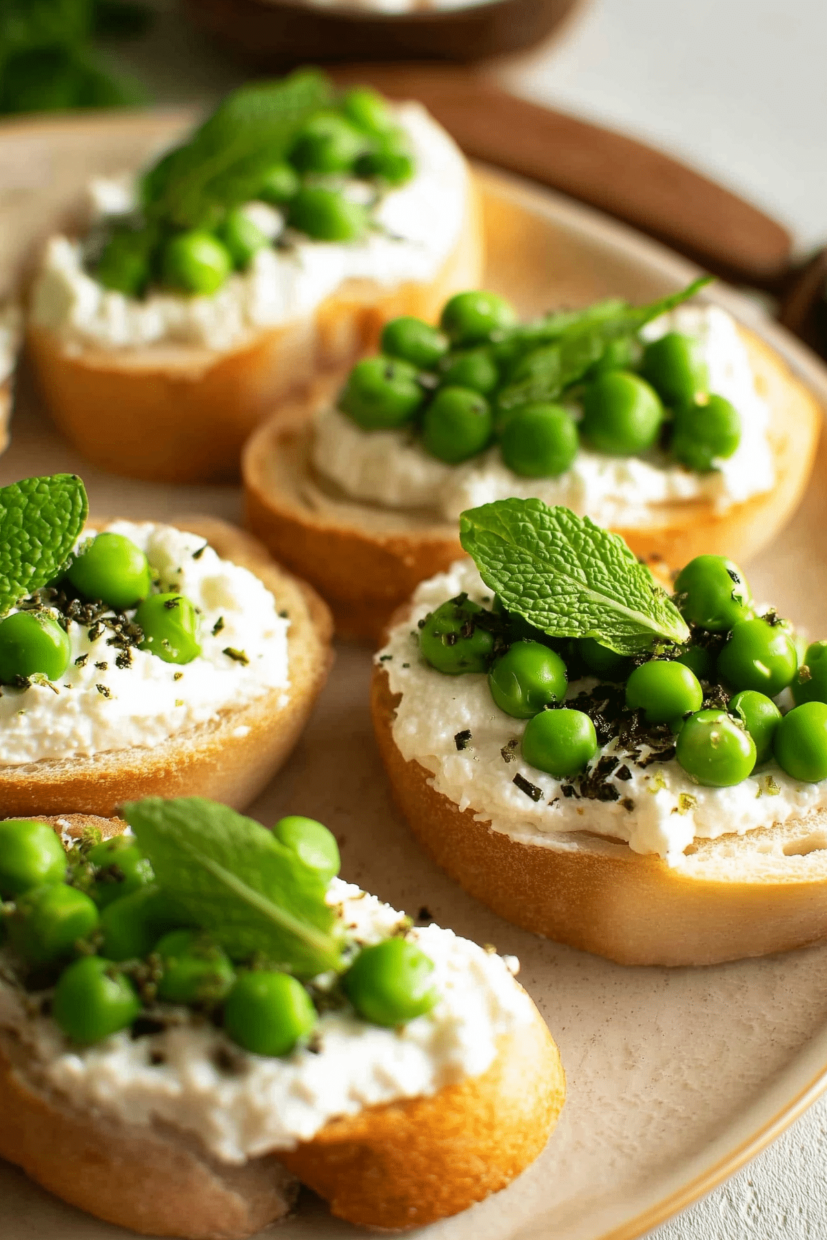 Ricotta Crostini with Peas and Mint appetizer on toasted baguette slices