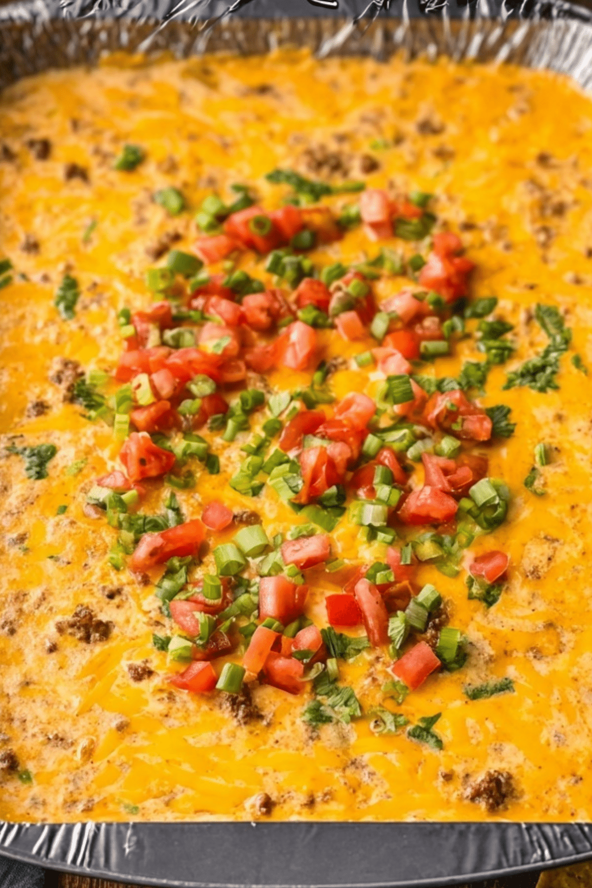 Smoked Queso Dip in a foil pan served with tortilla chips