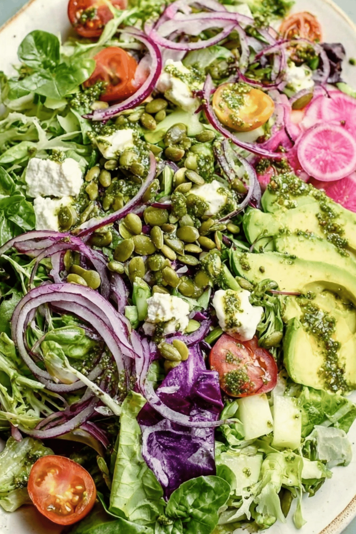 Green Salad with Basil Lemon Vinaigrette topped with fresh vegetables and creamy avocado