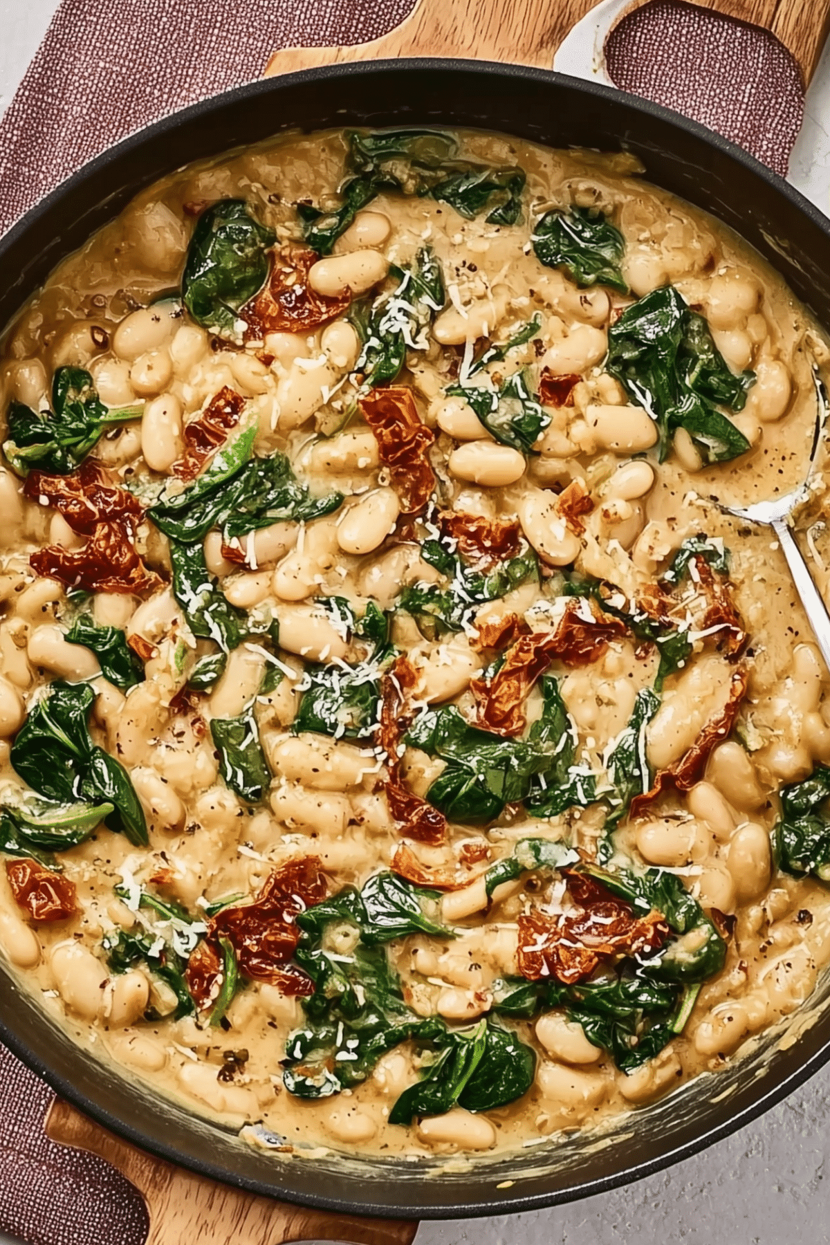 Marry Me White Bean & Spinach Skillet served in a skillet with fresh basil
