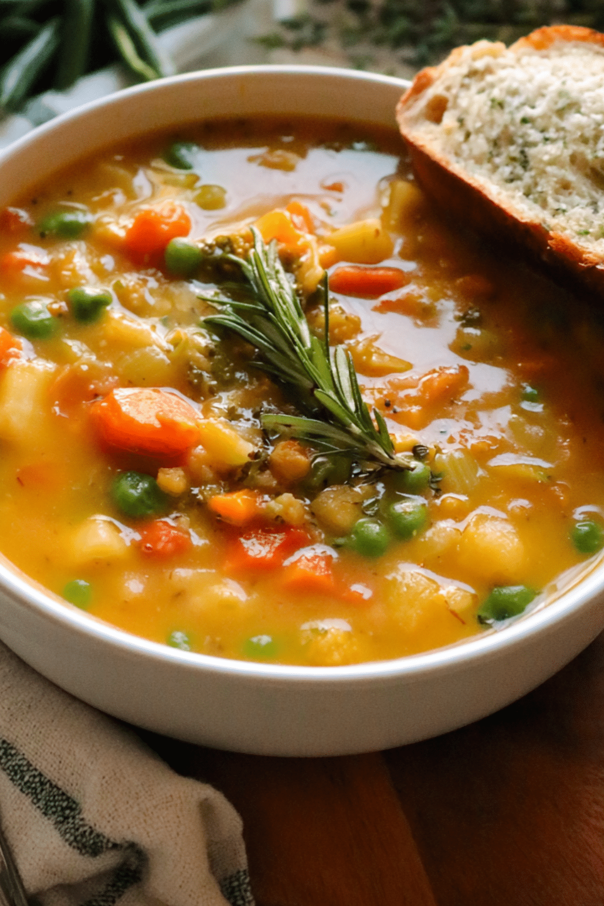 One Pot Vegetable Soup in a bowl with fresh vegetables and herbs